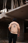 Beige oversized t shirt with bold “Karma” text and symbolic circular graphic – streetwear fashion graphic tee for men and women.